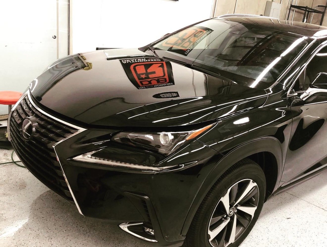 Glossy black Lexus SUV photographed under Chandler shop lighting