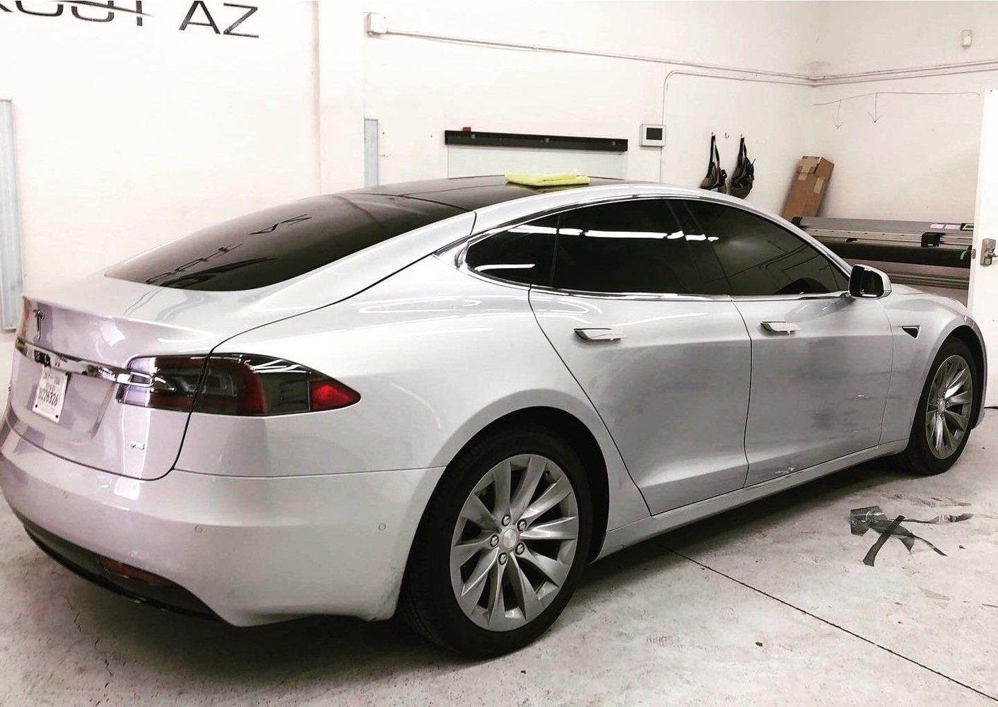 Silver Tesla Model S with tinted side and rear glass inside the Chandler shop